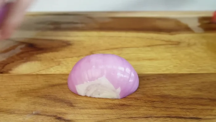 Picar la cebolla morada en tiras y luego en cubos (143.48).