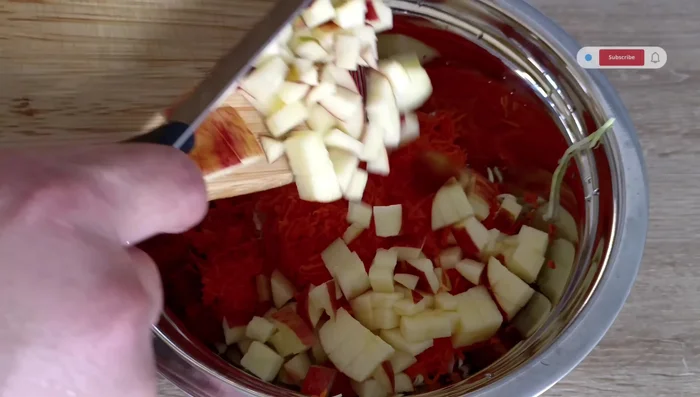 Combinamos los ingredientes (Receta 2): En una ensaladera, mezclamos el repollo escurrido, la zanahoria rallada, la manzana, 100g de uvas pasas, 200g de crema de leche, el jugo de 1-2 limones y 2 cucharadas de miel. Mezclamos suavemente.