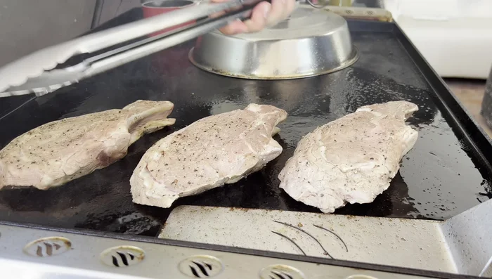 Sellar las chuletas de ternera en la plancha caliente durante 2 minutos por lado, bañándolas con la salsa griega y los jugos reducidos.