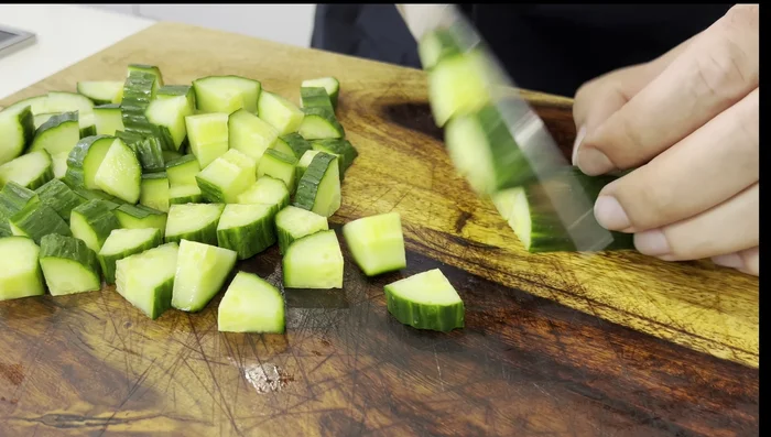Preparar la ensalada griega: picar el pepino, los tomates cherry, la cebolla morada, el pimentón verde y las aceitunas. Mezclar y reservar.
