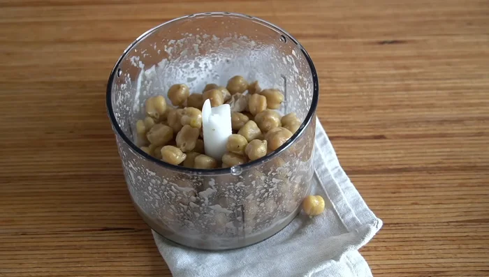 Añadir los garbanzos (algunos enteros, al gusto) al puré de ajo. Agregar más caldo para la consistencia deseada.