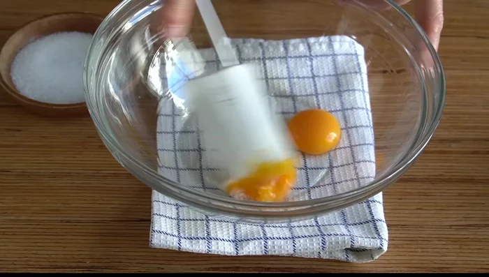Separar las yemas de las claras de 2 huevos. Añadir 2 g de sal, la levadura activada, el azúcar restante (40g en total), la ralladura de un limón y un chorrito de anís.