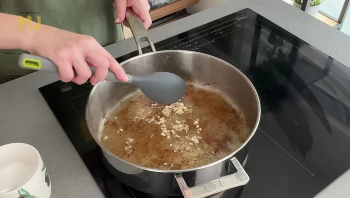 Añadir ajo picado y dorar ligeramente. Agregar cebolla picada, pizca de sal y sofreír a fuego medio hasta que esté pochada (unos 10 minutos).