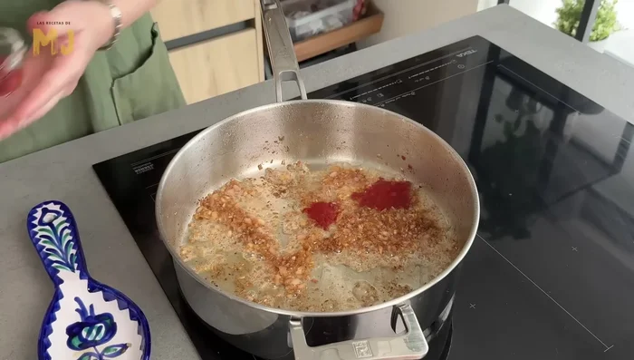 Incorporar pimiento choricero, tomate concentrado, tomate frito y remover. Añadir vino tinto, subir el fuego y dejar reducir 5 minutos.