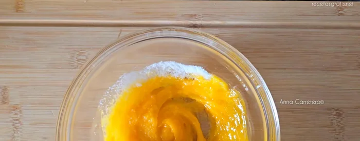 En un bol aparte, mezcla las yemas con 75g de azúcar, una cucharadita de vainilla, la ralladura de un limón, 80ml de nata y 120g de harina. Mezcla hasta que no queden grumos.
