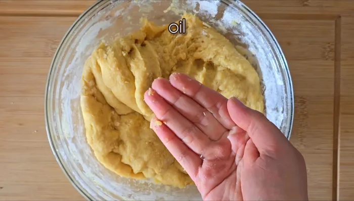 Untar las manos con un poco de aceite y formar bolitas del mismo tamaño. Presionar una bolita con otra y hacer un agujero en el centro para darles forma de roscos. (110.399)