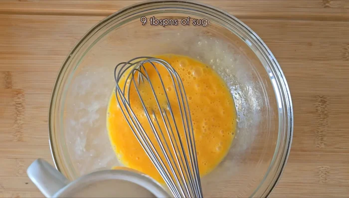 En un recipiente, mezclar 3 huevos grandes, 9 cucharadas de azúcar, la ralladura de una naranja y un limón, 9 cucharadas de zumo de naranja y 5 cucharadas de leche. (35.239)