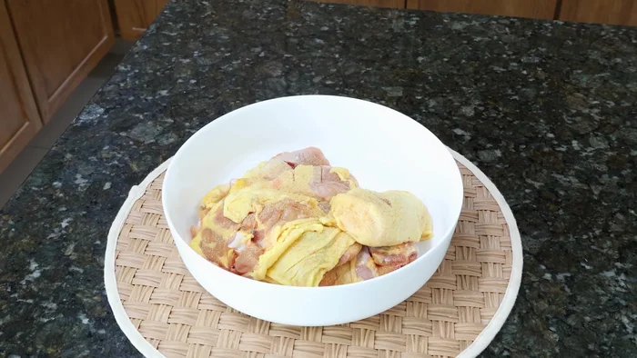 Sazonar el pollo con ajo en polvo, pimienta negra molida y sal. Mezclar bien con las manos limpias.