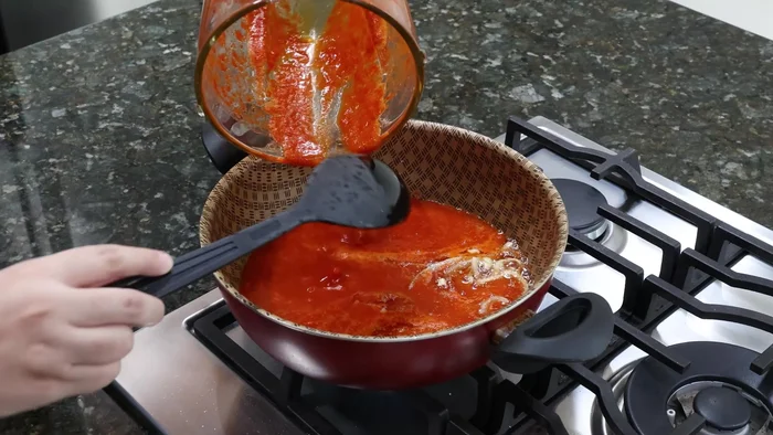 Agregar la salsa de guajillo a la cebolla sofrita y mezclar bien.
