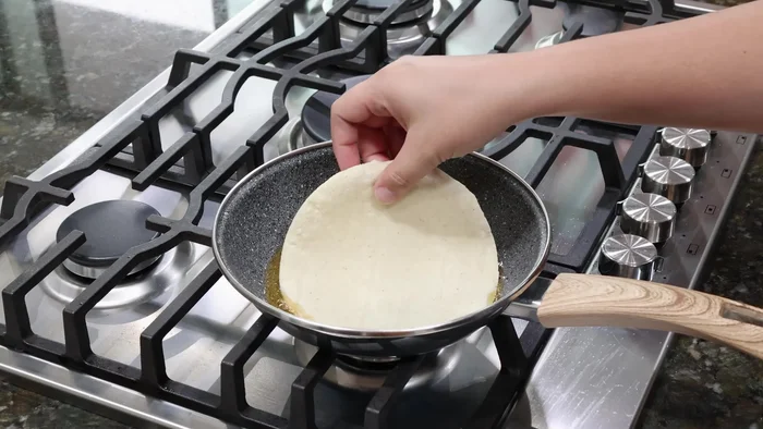 Untar tortillas con manteca derretida, cuidando que no se doren demasiado.