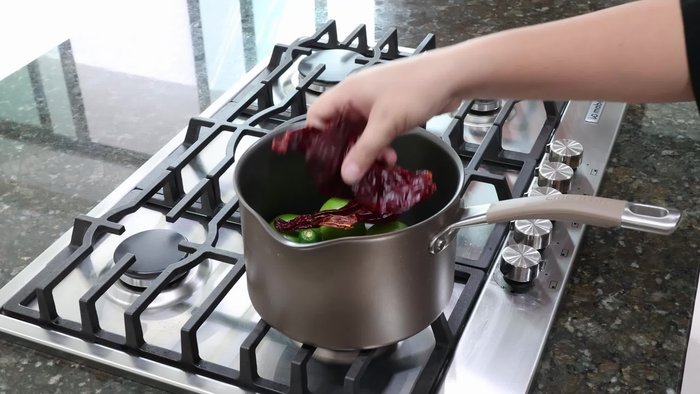 En otra olla, cocinar un pedazo de pechuga de pollo con una rodaja de cebolla, un diente de ajo sin cáscara y 2 hojas de laurel. Sazonar con sal y cocinar por un par de minutos.