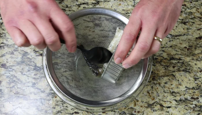 Escurrir las sardinas en un colador fino con un bol debajo.