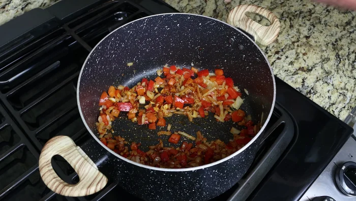 Incorporar media taza de salsa de tomate (168.16), llevar a hervor lento durante unos minutos (181.36).