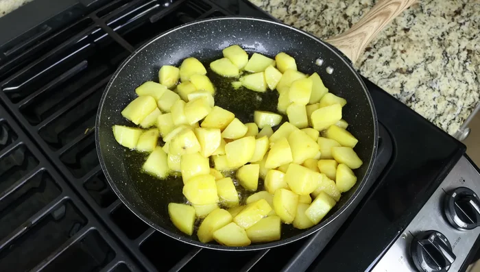Cuando las patatas estén doradas y cocidas (225.44), retirarlas de la sartén y escurrirlas en un colador (236.08). Reservar el aceite.