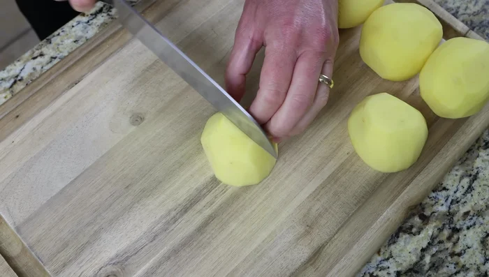 Cortar 1 kg de patatas peladas, lavadas y secadas en trozos de 2 cm (76.24).