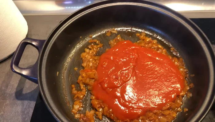 Agregar el tomate frito y dejar que el guiso reduzca un poco.