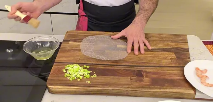 Hidratar las hojas de arroz con clara de huevo por ambos lados para evitar que se revien.