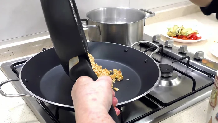 Pasar el arroz a una paella (o cacerola grande) y añadir agua hirviendo. [147.28]