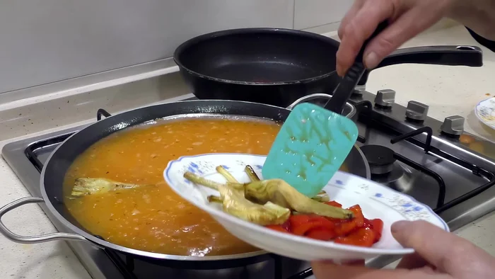 Incorporar las verduras reservadas (alcachofas, pimientos, judías verdes, guisantes y ajos) al arroz. [163.56]