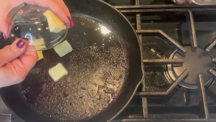 Agregar mantequilla a la sartén. Agregar cebolla y cocinar hasta que se ablande. Incorporar pasta de ajo.