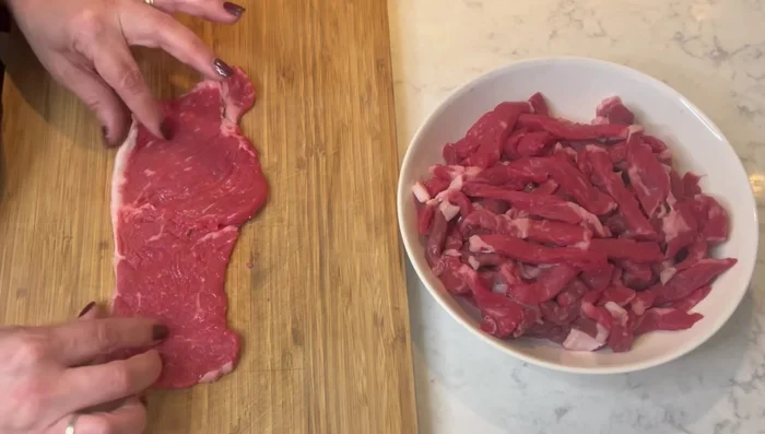 Cortar la carne de res en tiras finas.