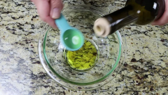 Preparar el aderezo mezclando el aceite de oliva virgen extra, el zumo de limón, el ajo rallado (o picado finamente), el orégano seco, la sal y la pimienta.