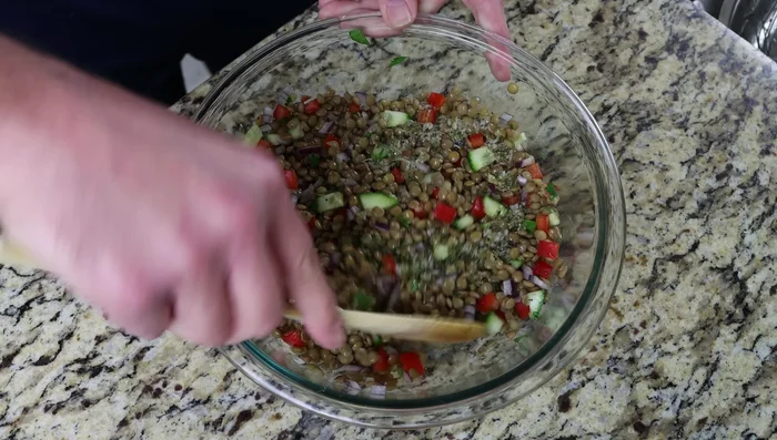Verter el aderezo sobre la ensalada de lentejas y mezclar suavemente.