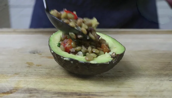 Rellenar los aguacates con la ensalada de lentejas.