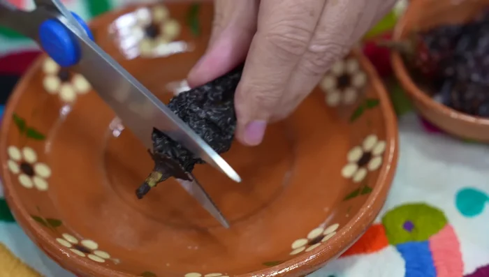 Cortar el rabito de los chiles morita con tijeras de cocina para que se hidraten mejor.