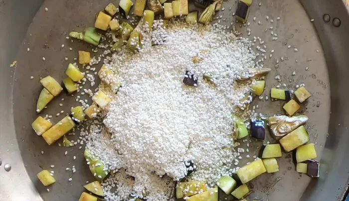 Nacarar el arroz: Sofreír el arroz durante un minuto a fuego medio para tostar ligeramente el almidón.