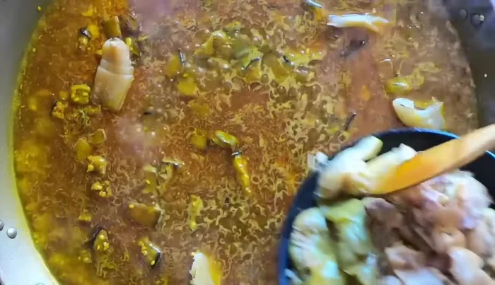 Distribuir el arroz en la paellera. Añadir las verduras y la carne desmechada de las manitas.