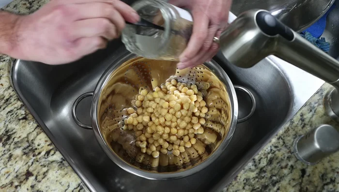 Escurrir los garbanzos en un colador y enjuagarlos con agua. Usar un frasco de 700g.