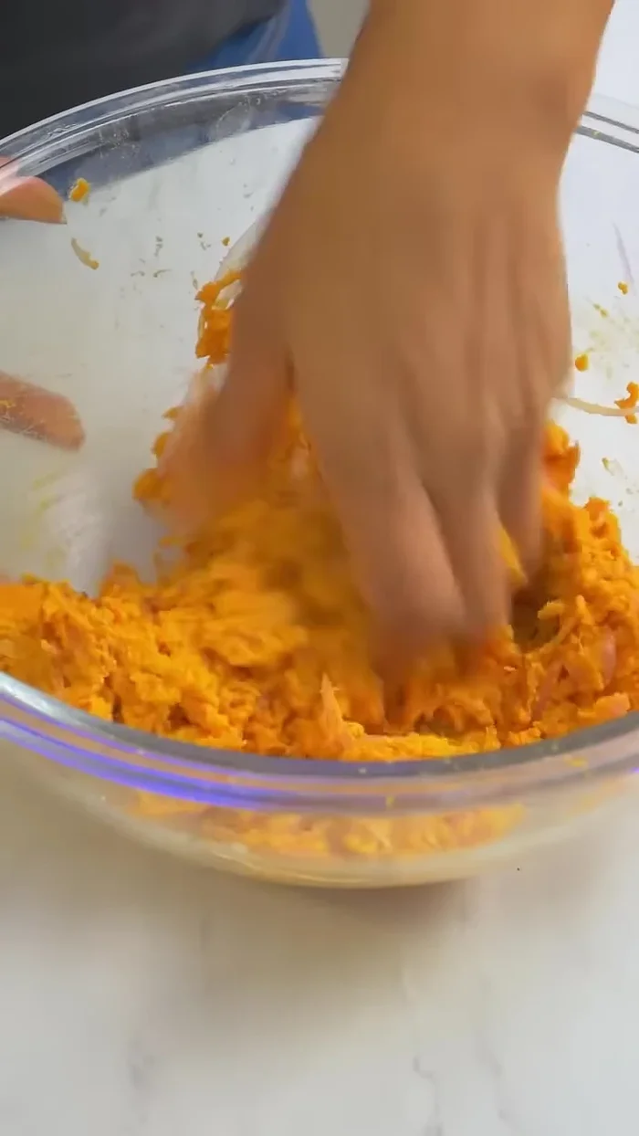 Humedece tus manos, toma un poco de masa, ponle en el centro media mitad de huevo y cúbrelo. 