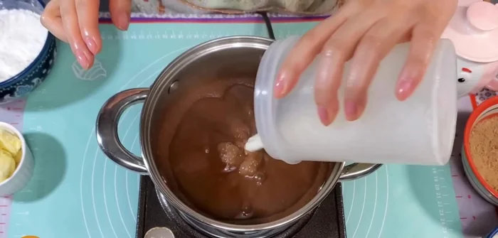 Agregar la mezcla de maicena a la olla con la leche y el cacao. Cocinar revolviendo constantemente hasta que espese y hierva.