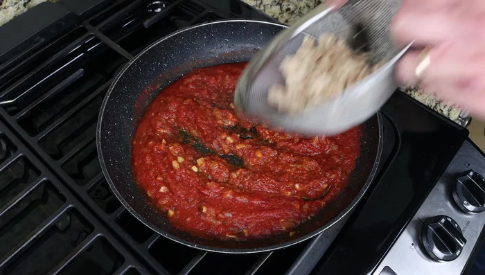 Apaga el fuego de la salsa de tomate. Agrega el atún escurrido y mezcla hasta integrar.