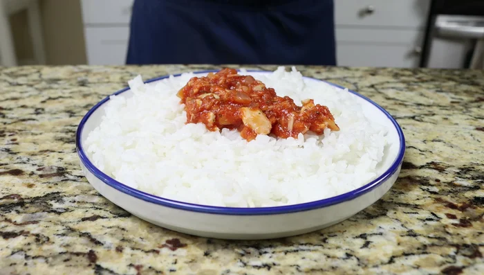 Sirve el arroz en una fuente, cúbrelo con la mezcla de atún y tomate, y decora con perejil fresco.