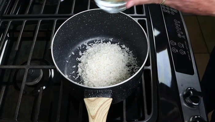 Cocina el arroz en una cacerola con 2 tazas de agua (480ml) y 1/2 cucharadita de sal marina (3g) a fuego alto hasta que hierva. Luego, baja el fuego a mínimo, tapa y cocina a fuego lento durante 18 minutos, o hasta que el agua se absorba por completo.