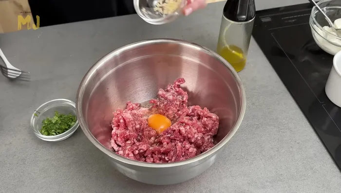Añadir el huevo, ajo picado, perejil, pan escurrido a la carne y mezclar bien con las manos.