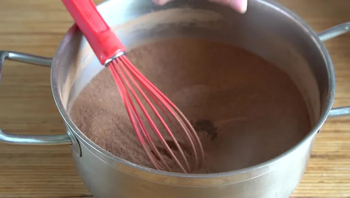 Añadimos la vainilla y un poco de leche, mezclando para evitar grumos. Incorporamos el resto de la leche (1L) poco a poco.