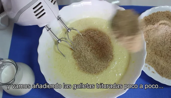 Añadir las galletas molidas poco a poco, mezclando hasta incorporarlas todas.