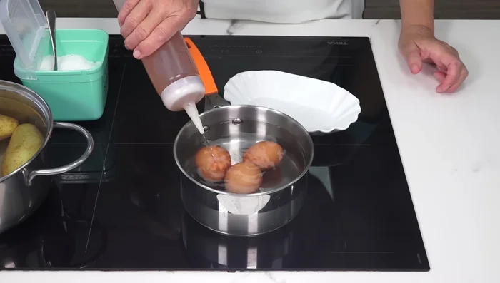 Cocer los huevos en agua con vinagre y sal a fuego medio hasta que estén listos (aprox. 10-12 minutos). Enfriarlos en agua con hielo para facilitar el pelado.