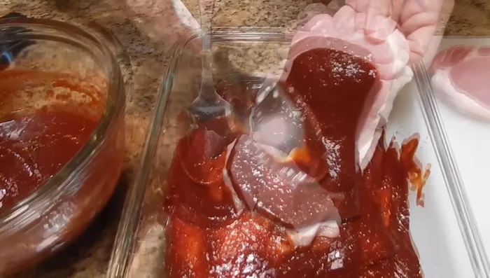 Untar el adobo en las chuletas de cerdo. Cubrir con papel plástico y refrigerar por al menos 4 horas (preferiblemente más).