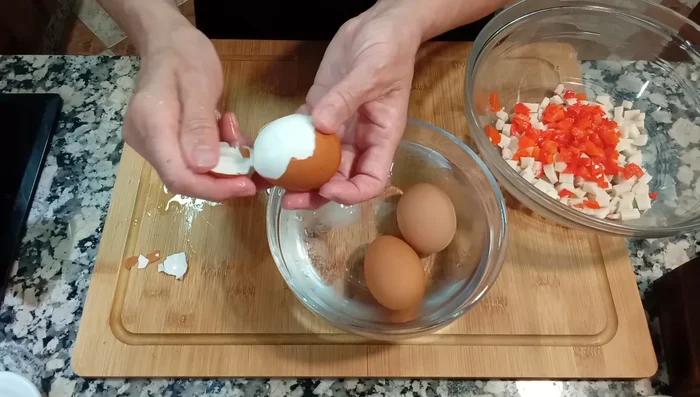 Una vez cocidos, pelar los huevos y trocearlos, reservando la yema para más tarde.