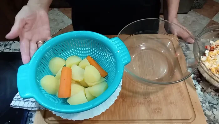 Escurrir las patatas y zanahorias cocidas. Chafarlas con un tenedor o chafador, sazonar con sal y dejar enfriar.