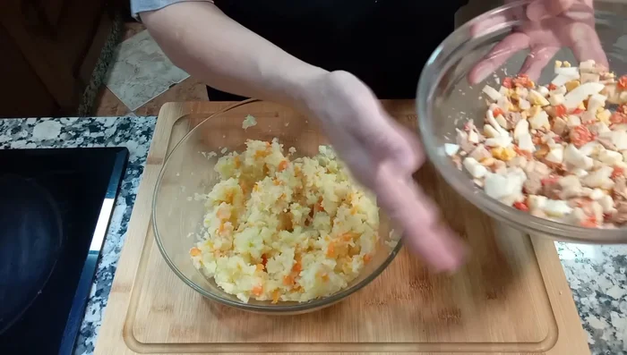 Una vez templadas las patatas, añadir la cola de surumi, los pimientos asados, el atún, los huevos troceados y la yema reservada.
