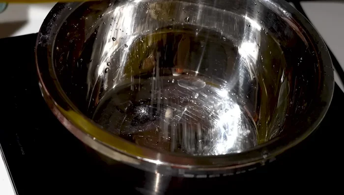Preparar la masa mezclando harina, almidón de maíz, sal, azúcar, bicarbonato, polvo para hornear, vinagre, huevo y agua hasta obtener una consistencia espesa y pegajosa.