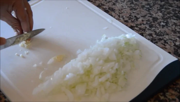 Picar finamente la cebolla y el ajo. (62.68)