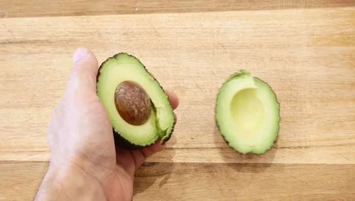 Cortar los aguacates por la mitad, retirar la pepita y hacer cortes verticales y transversales para facilitar la extracción de la pulpa en dados.