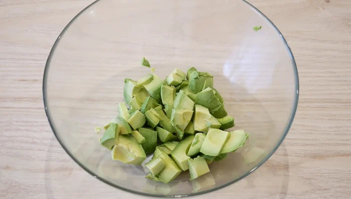 Añadir los dados de tomate al recipiente con el aguacate.