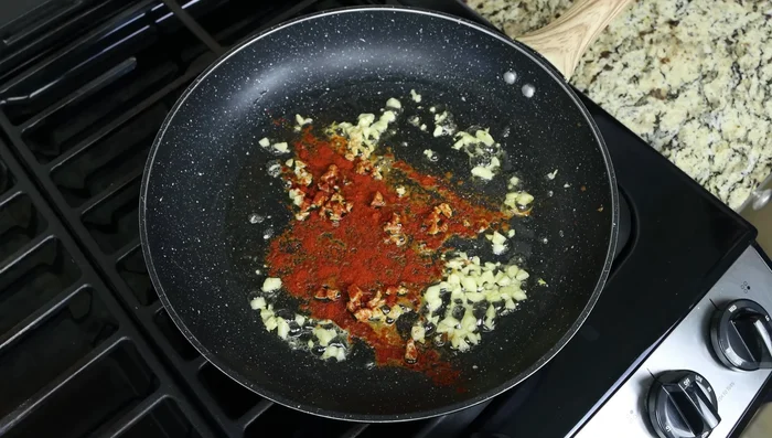Agrega el pimentón, tomillo y hojuelas de pimiento rojo. Mezcla rápidamente.